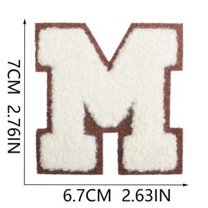 Macro detail of 7cm chenille letter M patch with white embroidery and coffee brown borders