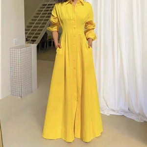 Detail of single-breasted yellow shirt dress with side pockets and elegant long sleeves