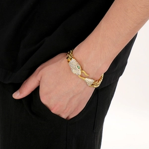 Detail of gold hip hop snake bracelet featuring diamond-encrusted head on a wrist
