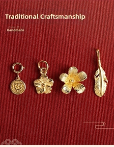 Close-up of gold-plated tiger, flower, and feather pendants in ancient craft finish