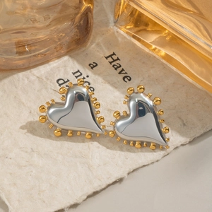 Boucles d'oreilles cœur géométriques argent et or avec bord perlé sur papier vintage