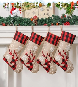 Detailed view of red plaid Christmas stockings with reindeer and snowflake embroidery