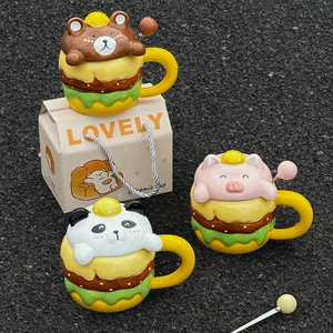 Detailed view of burger-shaped ceramic mugs with cute animal lids and matching spoons