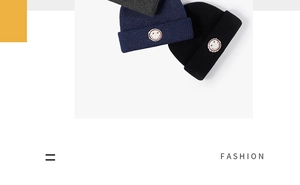 Detailed view of folded winter beanies in grey, navy, and black with smiley face patches