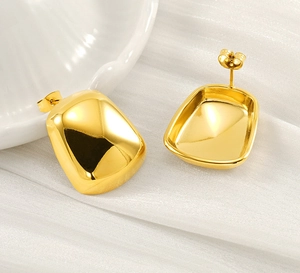 Detailed macro view of gold-tone rounded rectangle earrings showing a glossy mirror finish