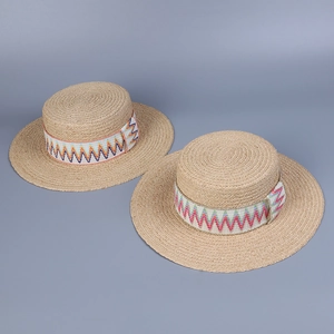 Close-up of hand-woven raffia sun hats with colorful zigzag embroidery on the brim