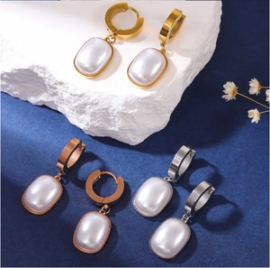 Detailed view of square pearl drop earrings in gold, rose gold, and silver finishes