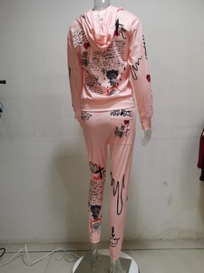 Detailansicht des rosa Trainingsanzugs mit schwarzen Graffiti-Buchstaben auf Hoodie und Hose
