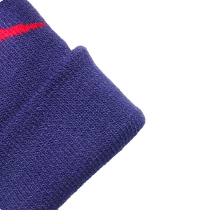 Close-up of navy blue knit fabric with red stripe detail on a warm winter hat