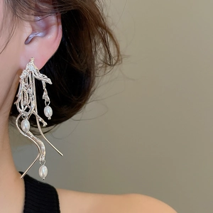 Close-up of elegant silver irregular wave tassel earrings with lustrous white pearls