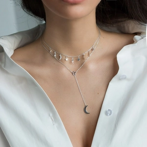 Detail shot of a double-layered S925 silver necklace featuring star and moon pendants