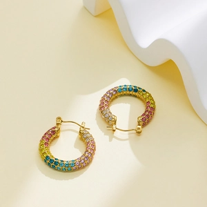 Macro shot of 18k gold-plated C-shaped earrings with colorful pavé micro-set rhinestones
