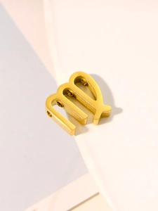 Macro shot of gold Virgo zodiac pendant with a polished metallic finish on white background