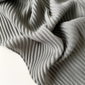 Close-up of grey pleated fabric texture showing soft folds and fine linen-like detail