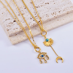 Macro view of gold evil eye and sun turquoise pendants on layered necklaces