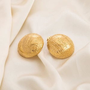Detailed close-up of gold 18K plated stainless steel earrings with woven texture