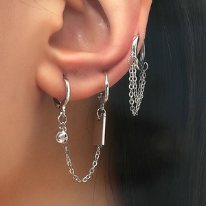 Close-up of silver geometric ear cuff set with micro-set zircon and chain pendants