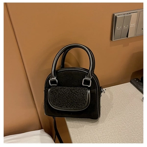 Detail of vintage black suede handbag with plush shearling pocket and rigid handle