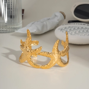 Vue détaillée d'un bracelet manchette étoile de mer doré avec texture martelée chic