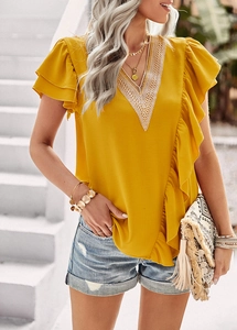 Detail of yellow V-neck blouse with white lace hollow stitching and ruffle sleeves