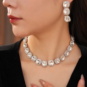 Detailed close-up of diamond tassel necklace and earring set on a female model