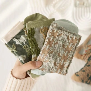 Close-up of vintage floral embossed textures on mid-calf socks in earthy green and yellow