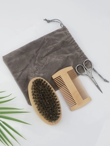 Macro view of a 4-piece men's beard grooming kit with wooden brushes and metal scissors