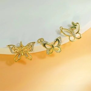 Detailed view of butterfly pendants with white and green cubic zirconia inlays