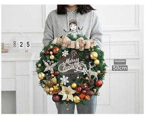 Détail d'une couronne de Noël de 50cm avec boules dorées, pommes de pin et signe Merry Christmas