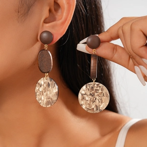 Detail view of vintage geometric drop earrings with wood and acrylic shell texture