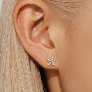 Close-up of gold starburst opal earrings with sparkling diamonds on female model