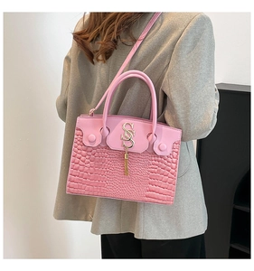 Pink crocodile-embossed handbag featuring a gold SS clasp and decorative tassel