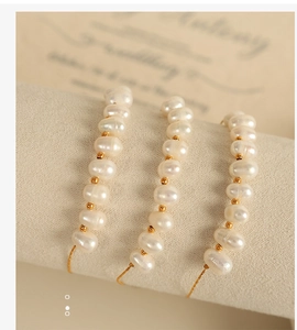 Vue détaillée de trois bracelets en perles naturelles avec chaînes plaquées or 18 carats