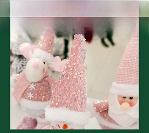 Detail of pink sequin hat and plush snowflake embroidery on a Christmas doll