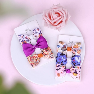 Detail of Halloween bow hair clips set featuring pumpkin and ghost prints on cards