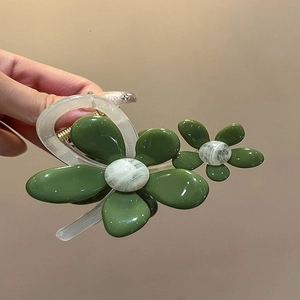 Details einer Blumen-Haarklammer mit olivgrünen Blütenblättern und marmorierten Blütenmitten