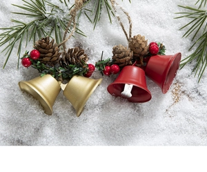 Detail of Christmas bell hanging with pine cones, red berries and festive greenery decor