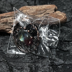 Macro detail of handmade wire-wrapped labradorite ring with vintage bronze bird nest design