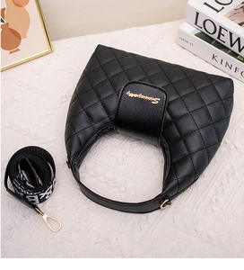 Detail of black quilted crescent handbag with gold logo and stylish logo webbing strap
