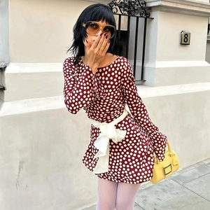 Detail of burgundy polka dot dress with large white waist ribbon bow for women