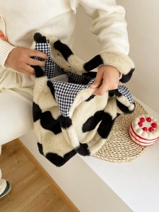 Detail of plush cow print tote bag showing interior checkered lining and spacious capacity