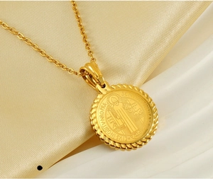 Macro shot of 18K gold plated St. Benedict medal pendant on stainless steel O-chain