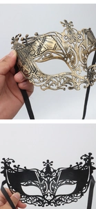 Detail of vintage masquerade masks in antique bronze and black with ornate relief patterns