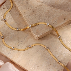 Detail of gold herringbone snake chain necklace with clear cubic zirconia on silk