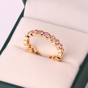 Detail of 18k gold plated ring with pink cubic zirconia stones in a velvet jewelry box