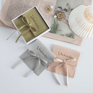 Close-up of microfiber jewelry pouches with elegant ribbon ties and Vinknde branding