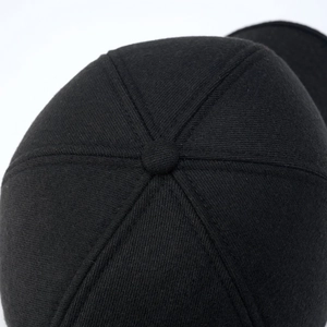 Detailed close-up of a black winter baseball cap crown with six-panel stitching and top button