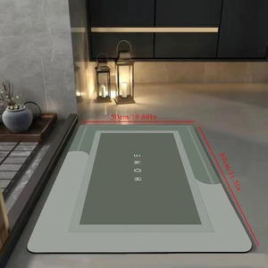 Detail showing grey-green diatom mud bath mat with 3D HOME text design, 50x80cm size