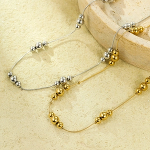 Chic gold and silver stainless steel ball bead necklaces on a beige stone surface