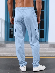 Detail view of light blue straight-leg cargo pants with functional side flap pocket